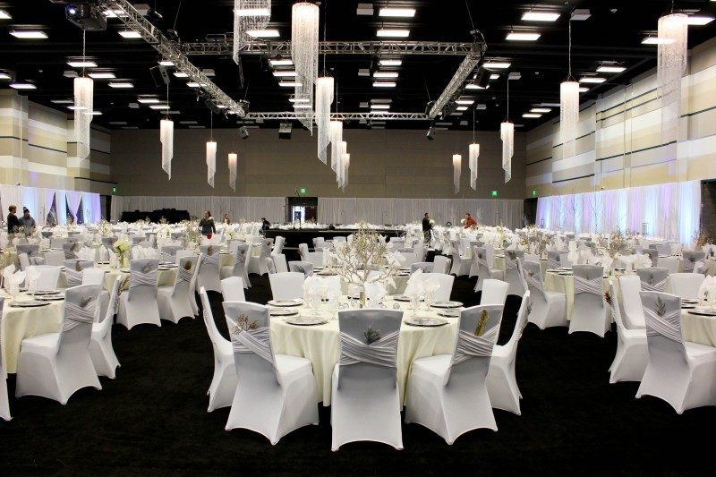 hall with white draped tables and hanging crystal chandeliers