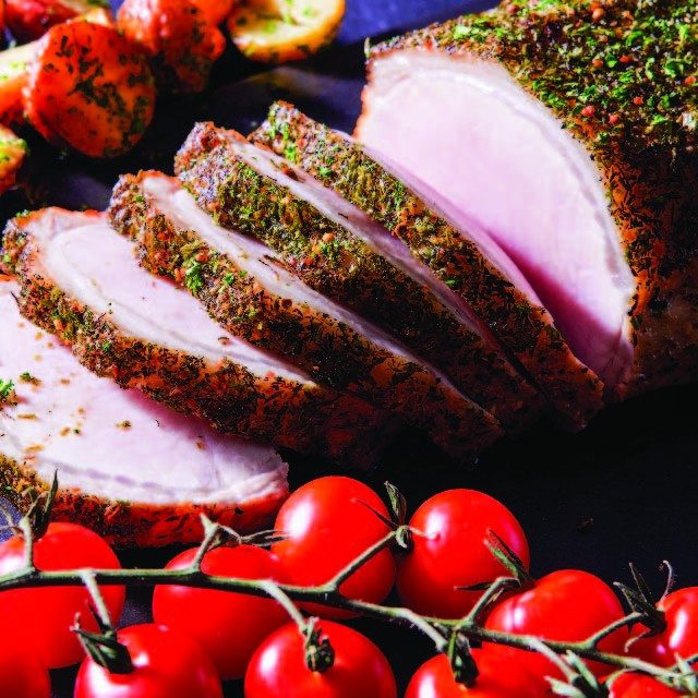 sliced pork loin with tomatoes on the vine and sliced roasted potatoes