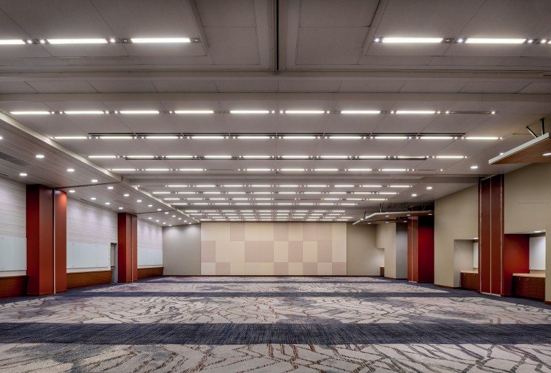 Empty room with red and beige walls, well-lit, and multi-colored carpet.