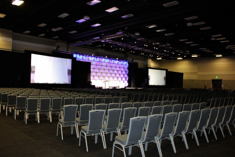 Empty conference hall a large projector screen on stage.