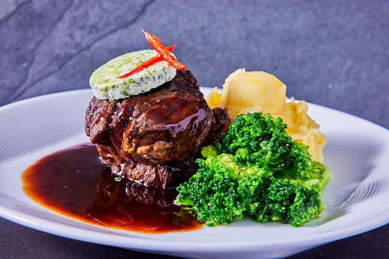 herb butter, mashed potatoes, broccoli, and gravy