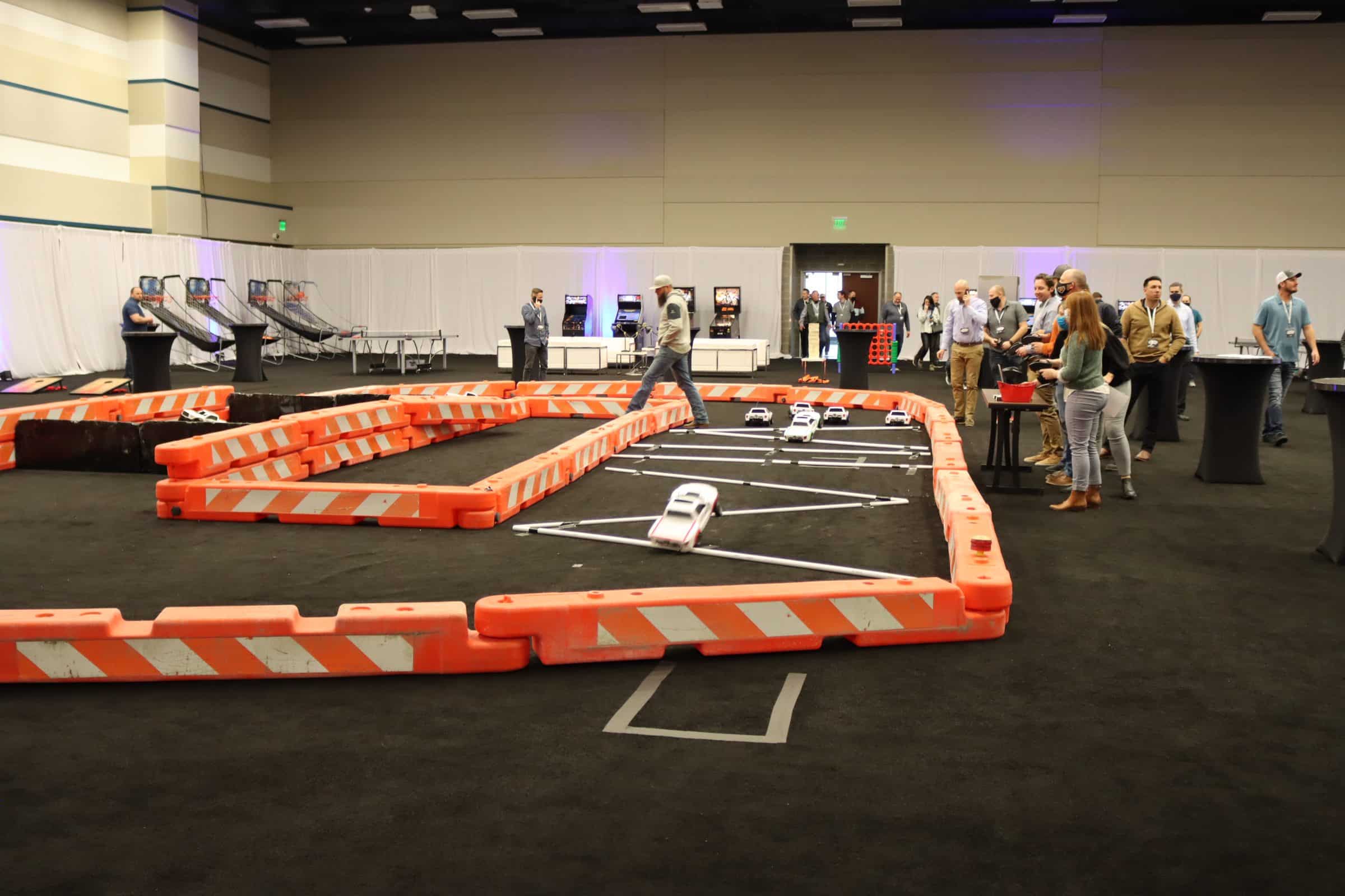 An indoor racing track with spectators and a race in progress.