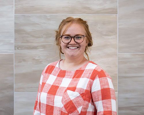 woman with red hair wearing a red gingham shirt