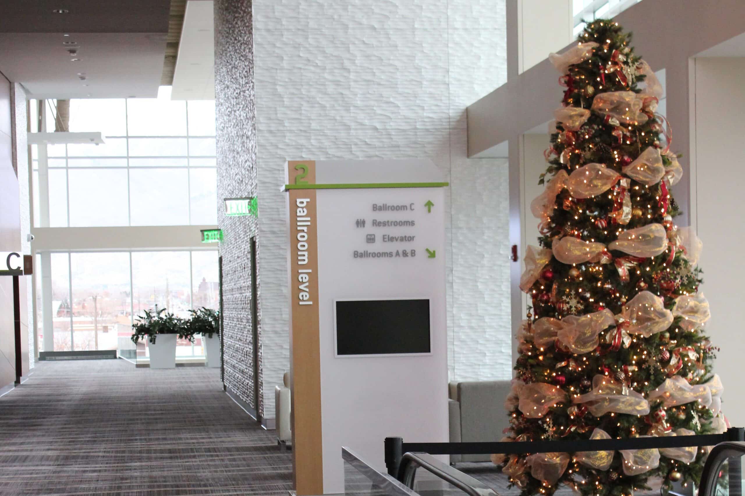 Indoor hallway with signage and decorated Christmas tree