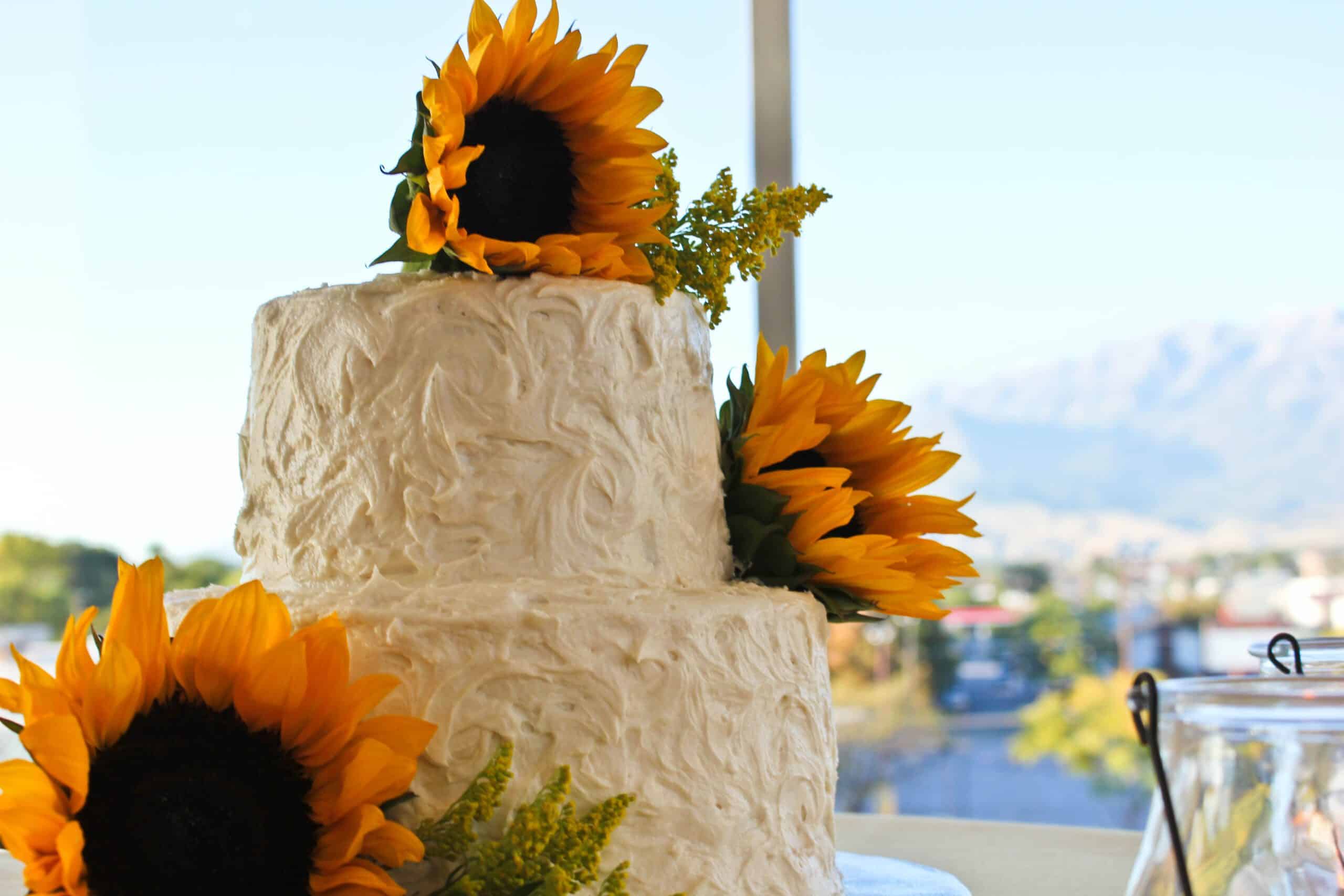 Two-tiered white cake with sunflower